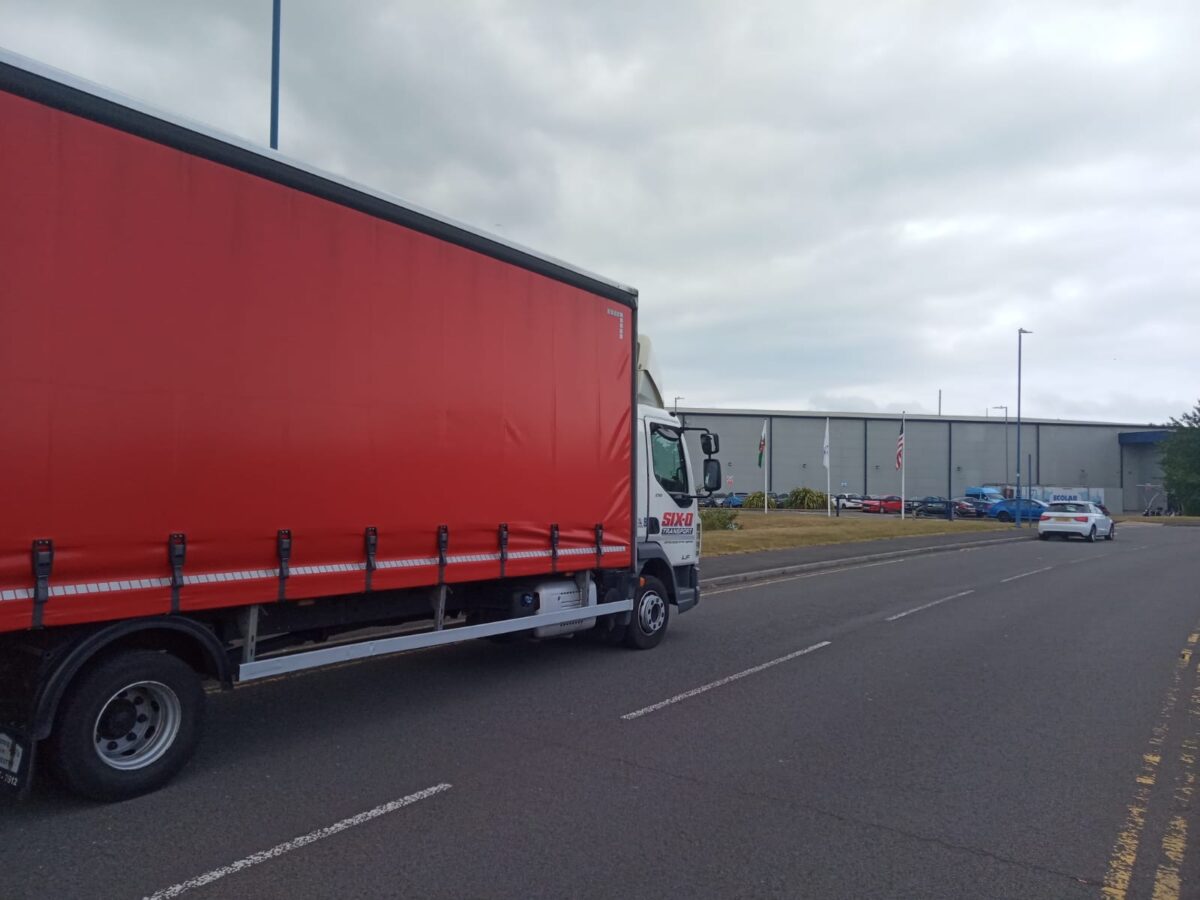 Side view of a Six-O curtainside lorry out on the road