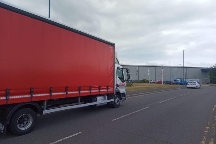 Side view of a Six-O curtainside lorry out on the road